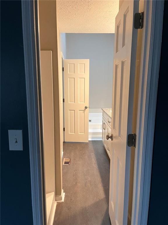 corridor with visible vents and a textured ceiling