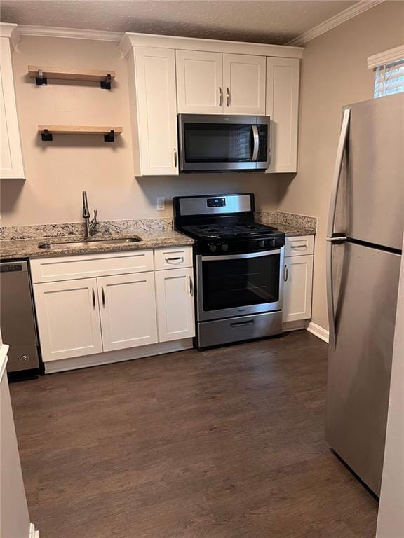 kitchen featuring dark wood-style floors, a sink, stainless steel appliances, white cabinetry, and crown molding