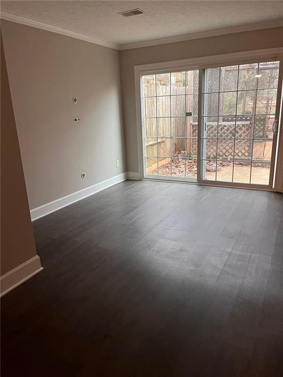 empty room featuring visible vents, a textured ceiling, crown molding, and baseboards