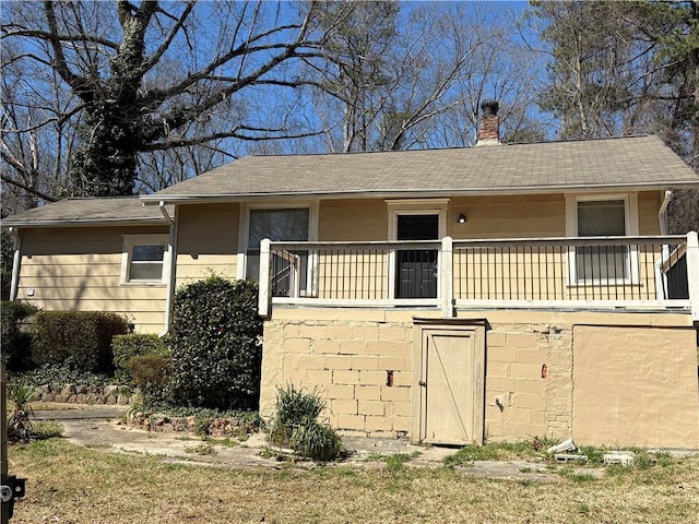 view of front of property with a shingled roof and a chimney
