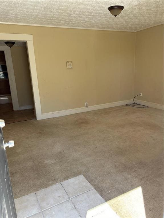 unfurnished room featuring baseboards, carpet floors, and a textured ceiling