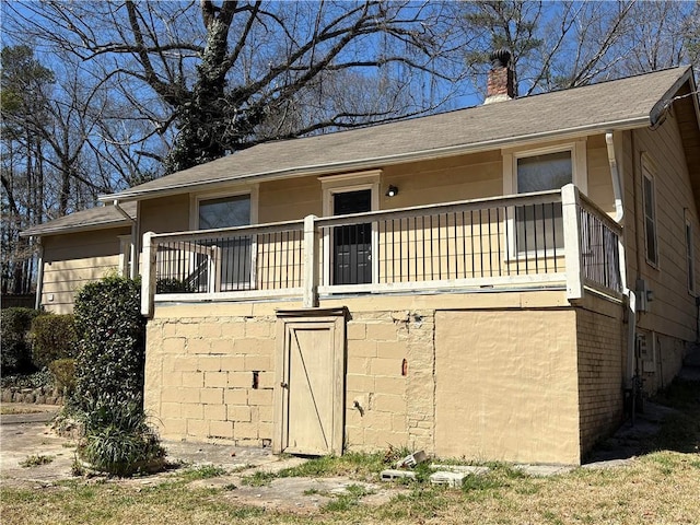 view of home's exterior featuring roof with shingles and a chimney