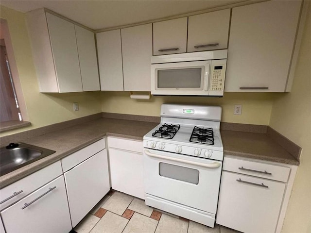 kitchen featuring white appliances, sink, and white cabinets