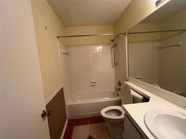 full bathroom featuring tile patterned floors, toilet, tiled shower / bath combo, vanity, and a textured ceiling