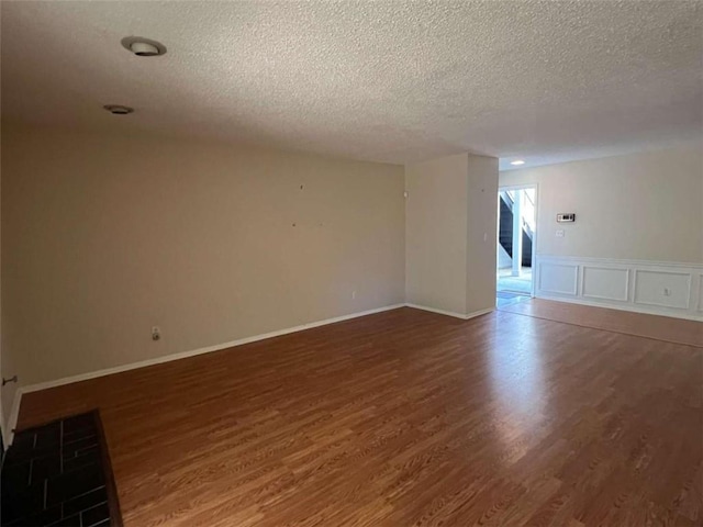 unfurnished room featuring dark wood-type flooring and a textured ceiling