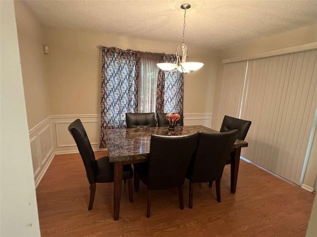 dining space featuring a textured ceiling and hardwood / wood-style flooring