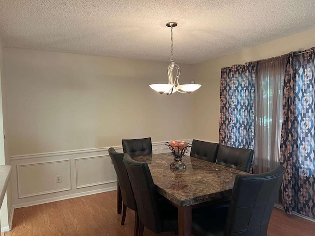 dining area with hardwood / wood-style floors and a textured ceiling