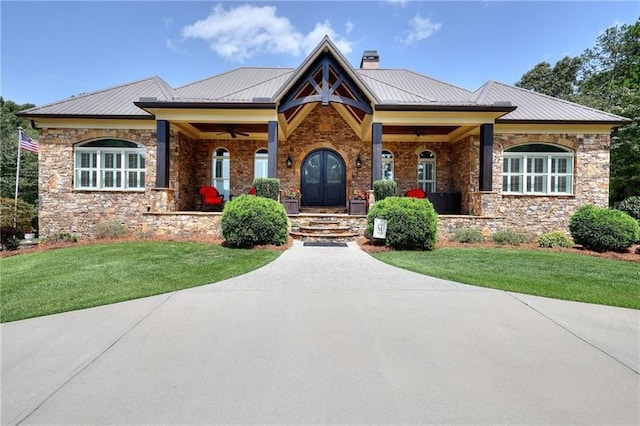 craftsman inspired home featuring metal roof, a front yard, french doors, a standing seam roof, and a chimney