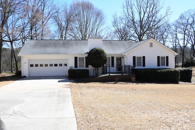 ranch-style home with a chimney, a shingled roof, concrete driveway, an attached garage, and a front lawn