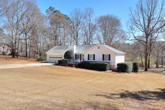 ranch-style home with driveway, an attached garage, and a front yard