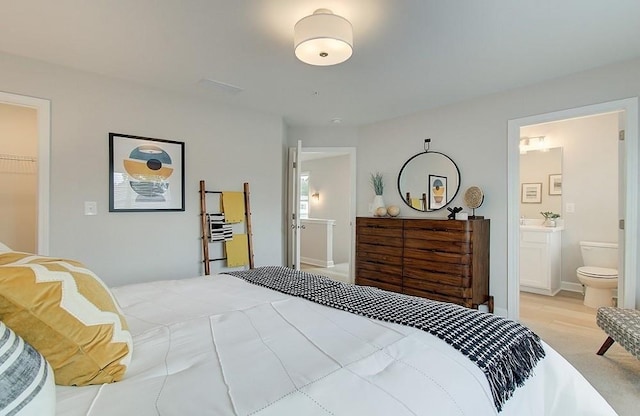 bedroom with a closet, a spacious closet, and ensuite bath