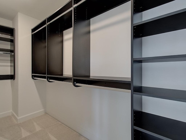 walk in closet featuring light colored carpet