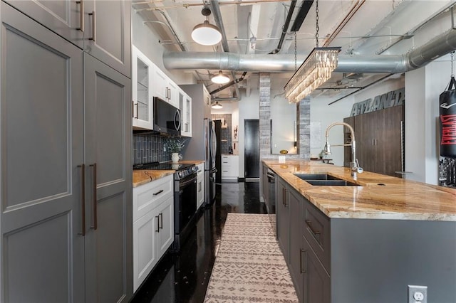 kitchen featuring a sink, stainless steel appliances, light stone counters, gray cabinetry, and white cabinetry