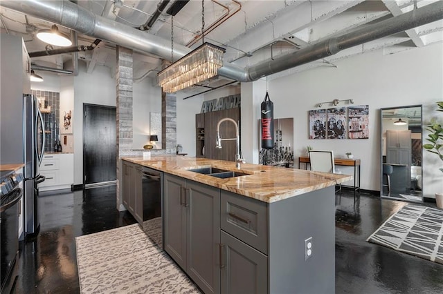 kitchen with a sink, gray cabinetry, a high ceiling, appliances with stainless steel finishes, and light stone countertops