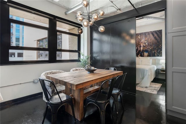 dining area featuring a chandelier and baseboards