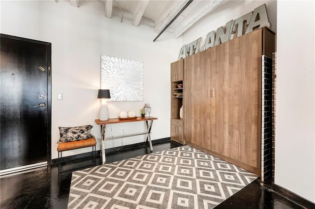 living area with beamed ceiling, a towering ceiling, and baseboards