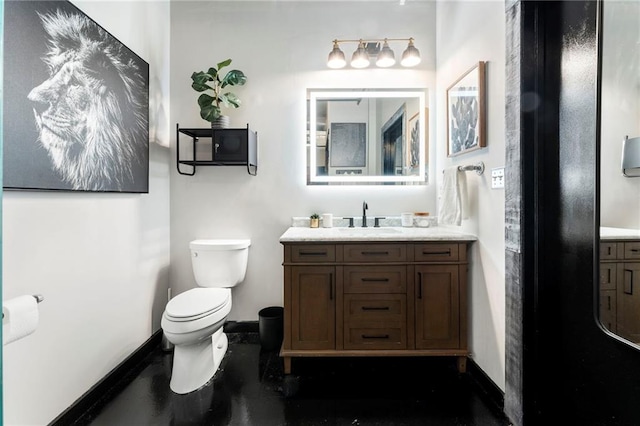 bathroom featuring baseboards, toilet, and vanity