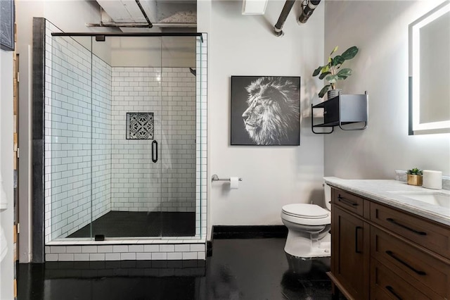 bathroom featuring toilet, a stall shower, and vanity
