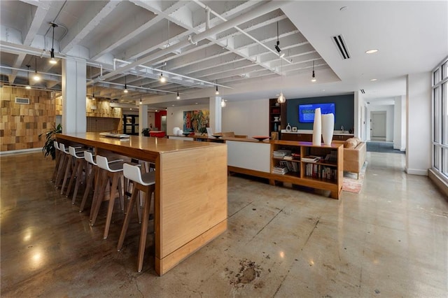 indoor dry bar with concrete floors, baseboards, and hanging light fixtures