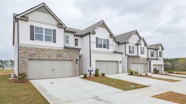 view of front of home with concrete driveway, stone siding, board and batten siding, and an attached garage