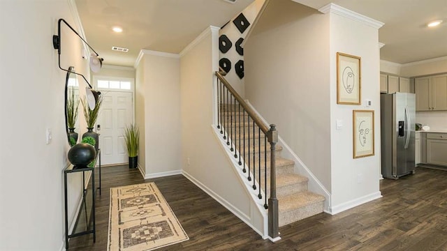 foyer entrance with baseboards, visible vents, dark wood-style flooring, and ornamental molding