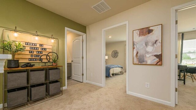 hall with light colored carpet