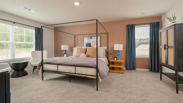 carpeted bedroom with multiple windows, visible vents, and baseboards