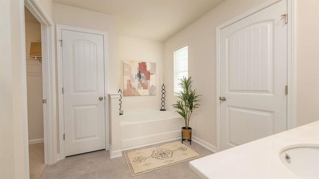 full bath featuring a sink, baseboards, and a bath