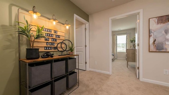 corridor featuring baseboards and light colored carpet