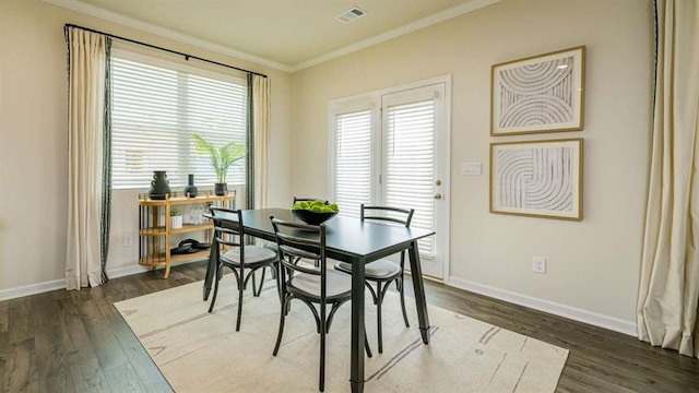 dining room featuring crown molding, dark wood-type flooring, and a wealth of natural light