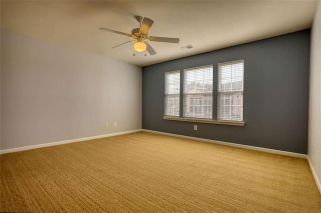 carpeted spare room featuring ceiling fan