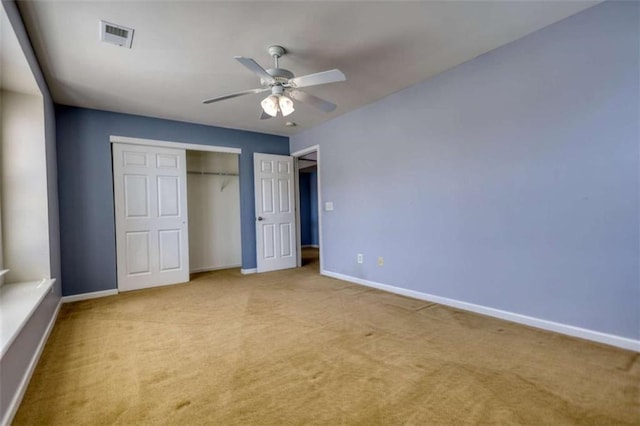 unfurnished bedroom with ceiling fan, a closet, and light carpet