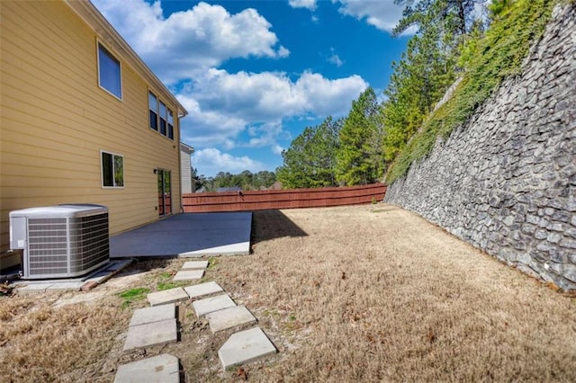 view of yard with central AC and a patio