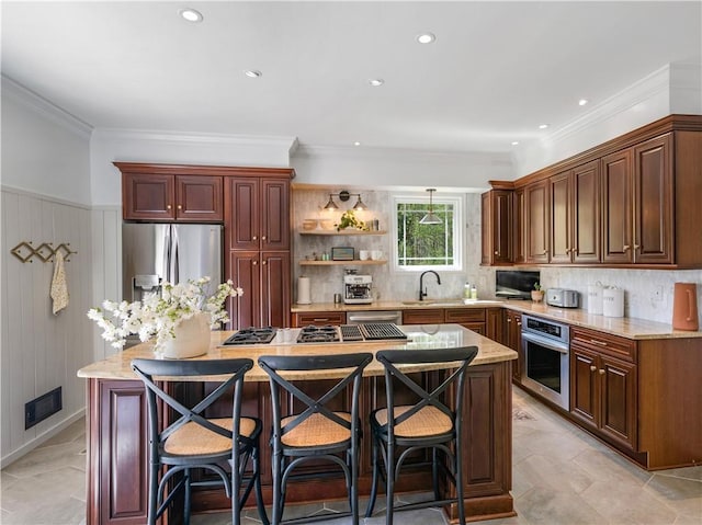 kitchen with light stone counters, a sink, a center island, stainless steel appliances, and visible vents