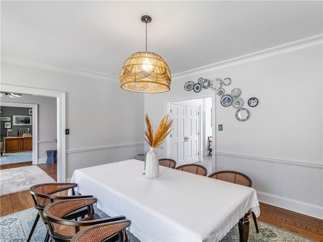 dining area with crown molding, baseboards, and wood finished floors