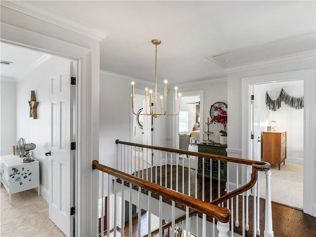 hall featuring baseboards, attic access, an upstairs landing, and ornamental molding