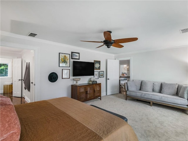 carpeted bedroom featuring crown molding, baseboards, a ceiling fan, and visible vents