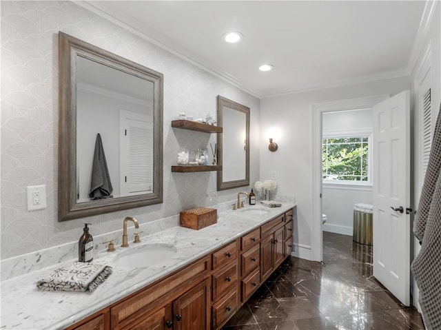 bathroom with double vanity, a sink, crown molding, and toilet