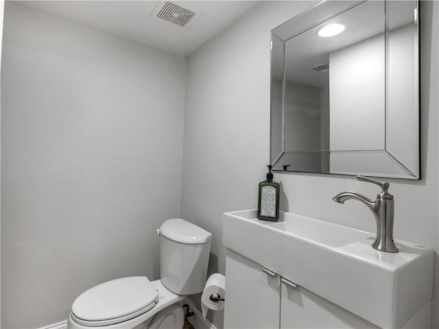 half bathroom featuring toilet, baseboards, visible vents, and recessed lighting
