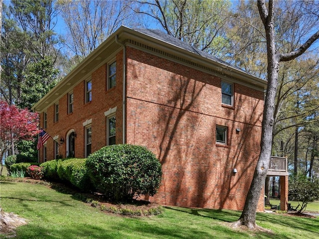 view of property exterior with a lawn and brick siding