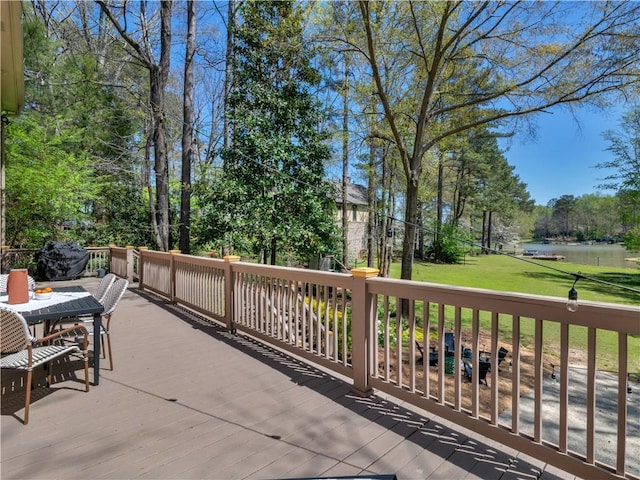 view of patio with a deck with water view and outdoor dining area