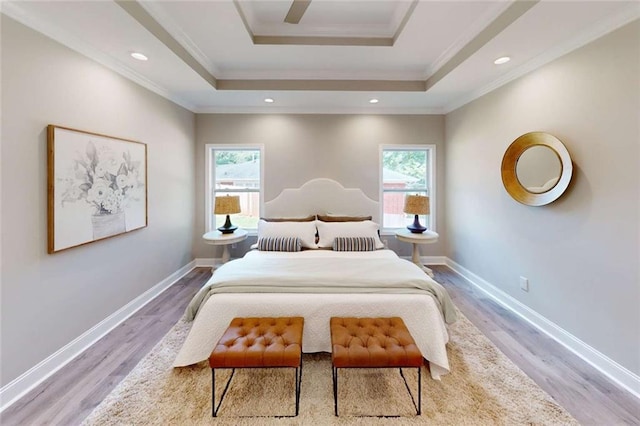 bedroom with multiple windows, a raised ceiling, baseboards, and ornamental molding