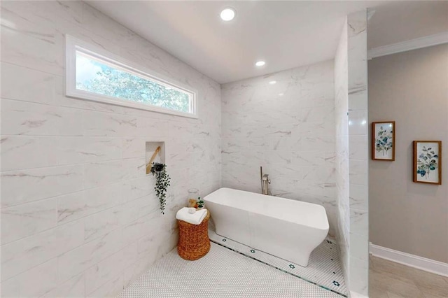 full bathroom featuring tile walls, recessed lighting, baseboards, and a freestanding bath