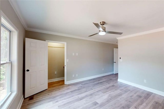 empty room featuring baseboards, ceiling fan, crown molding, and light wood finished floors