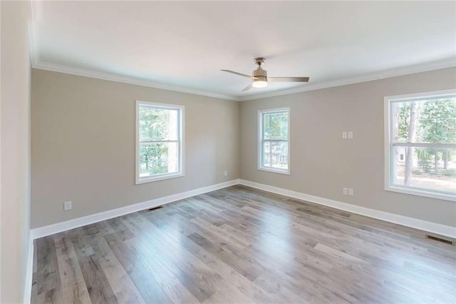 unfurnished room with visible vents, ceiling fan, baseboards, ornamental molding, and wood finished floors