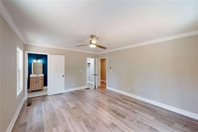 unfurnished bedroom featuring a ceiling fan, baseboards, ensuite bathroom, crown molding, and light wood-type flooring