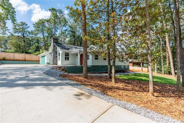 single story home with a garage, concrete driveway, and fence