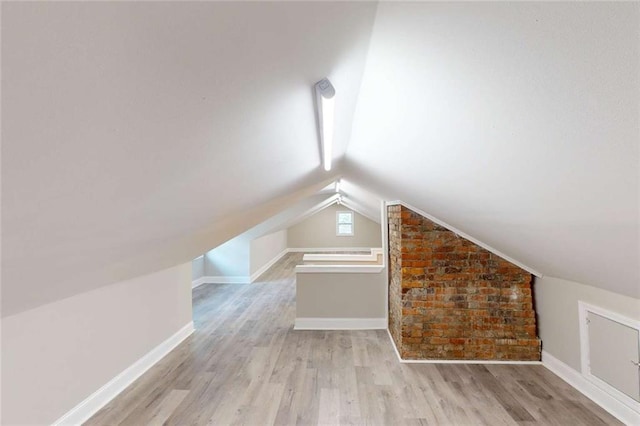 bonus room featuring baseboards, lofted ceiling, and wood finished floors