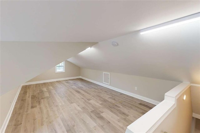 bonus room with lofted ceiling, wood finished floors, and baseboards