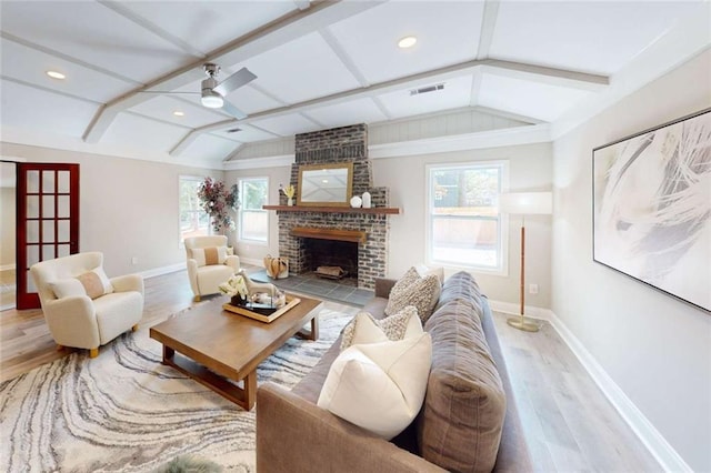 living area with a wealth of natural light, visible vents, lofted ceiling with beams, and ceiling fan